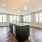 unfurnished kitchen adjacent with bright living room with lots of large windows
