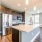 Open kitchen area with large island near bright living room with lots of large windows