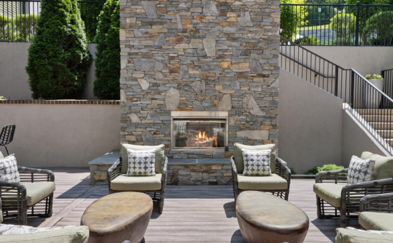 Outdoor lounge area with firepit near the pool