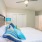 Triangular bedroom lit by a central ceiling fan light