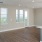 Living area by kitchen with large windows and door to patio